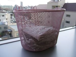 写真：かごに入れた生ごみを新聞紙で乾燥させている様子