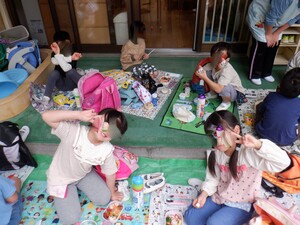 保育園のベランダでお弁当を食べる園児たち