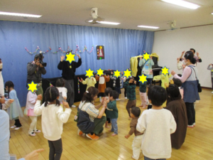 画像：ダンスを踊る保育士と子どもたち