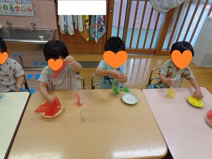 花紙をちぎりペットボトルに入れる様子